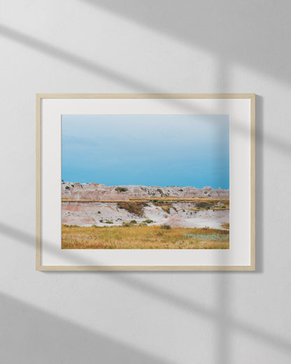 Framed photograph of a landscape with a clear blue sky and natural scenery.
