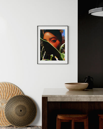 Framed artwork on a wall above a table with decorative items.